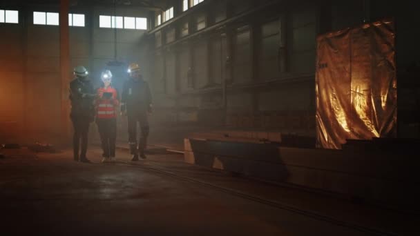 Ingénieur industriel et les travailleurs avec des lampes de poche marchent dans l'usine d'acier — Video