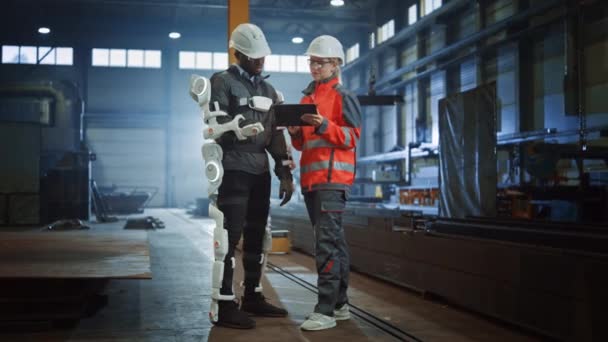 Industriële Fabriek Werknemer dragen Exoskelet Gesprekken met ingenieur bij Steel Factory — Stockvideo