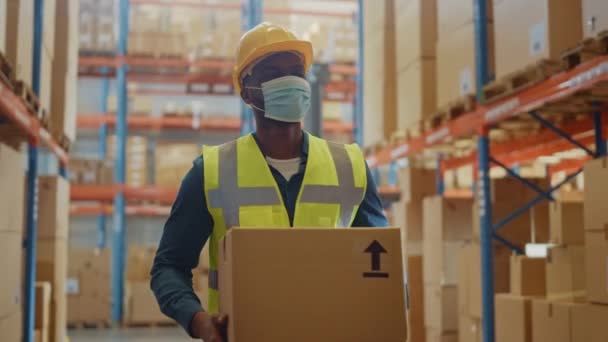 Hombre guapo del almacén grande que usa la máscara que camina con la caja — Vídeos de Stock