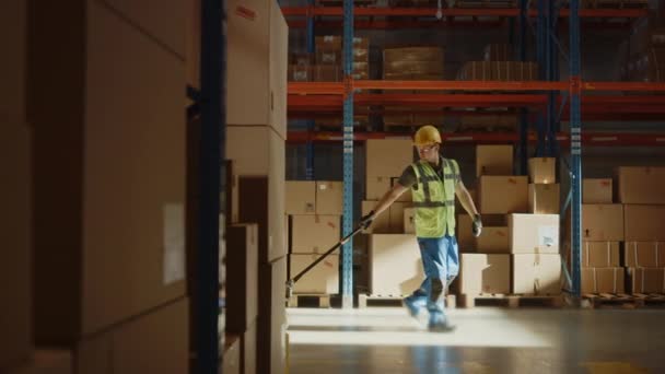 Raktármunkás kézi emelőkocsit használ — Stock videók