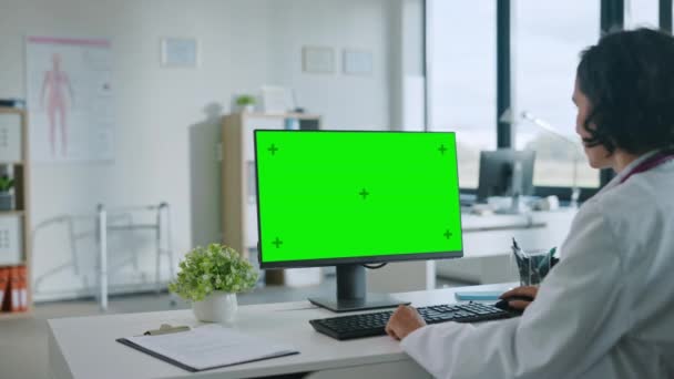 Médico trabalha no computador com tela verde — Vídeo de Stock