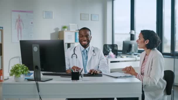 Lääkärilääkäri puhuu potilaalle sairaalan toimistossa — kuvapankkivideo