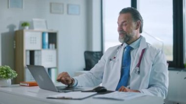 Tıp doktoru laptopta video çağrısı yapıyor.