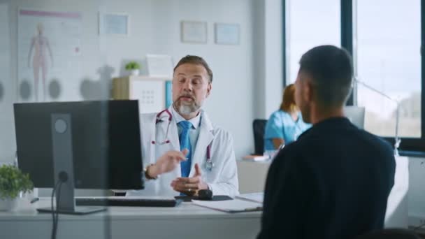 Lekarz rozmawia z pacjentem w gabinecie szpitalnym. — Wideo stockowe