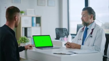Tıbbi Doktor, Laptop 'ta Hasta ile Konuşuyor ve Yeşil Ekran Modeli Kullanıyor