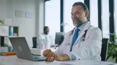 Tıp doktoru laptopta video çağrısı yapıyor.