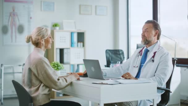 Orvos beszél a beteggel a kórházi irodában. — Stock videók
