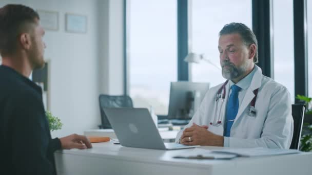 Medische dokter praat met patiënt in ziekenhuis kantoor — Stockvideo