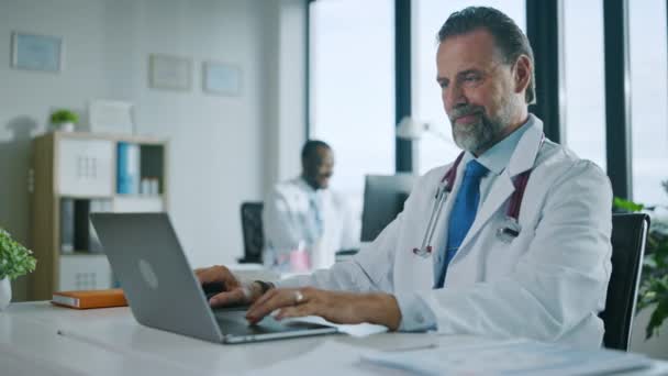 Médico trabaja en la computadora en la oficina del hospital — Vídeo de stock