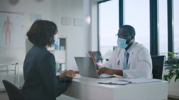 Medische dokter praat met patiënt dragen van gezichtsmaskers — Stockvideo
