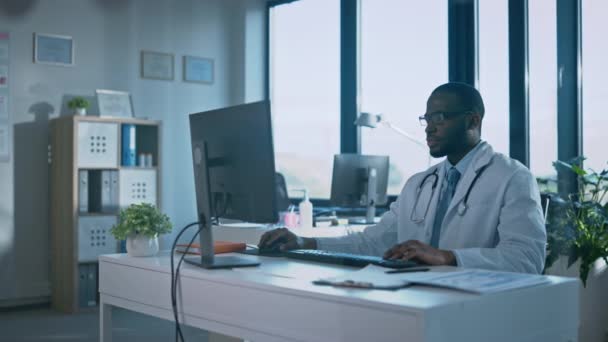 Médico trabaja en la computadora en la oficina del hospital — Vídeo de stock