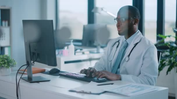Médico trabaja en la computadora en la oficina del hospital — Vídeo de stock
