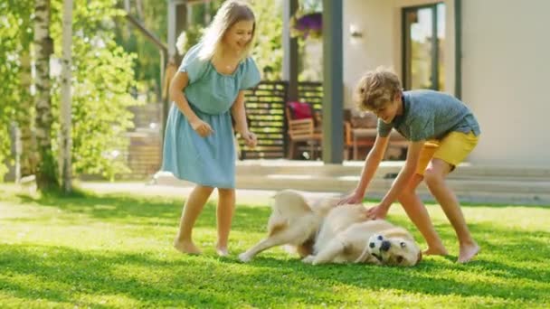 Τα παιδιά παίζουν με το σκυλί Golden Retriever στην πίσω αυλή — Αρχείο Βίντεο