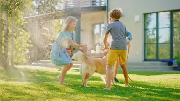 Vader dochter en zoon spelen met slang Golden Retriever Dog in de achtertuin — Stockvideo