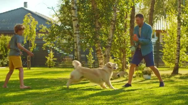 Батько і син бавляться з золотим собакою на задньому дворі — стокове відео