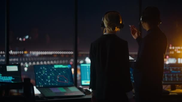 Especialistas en Control de Tráfico Aéreo Hablando en la Torre del Aeropuerto por la Noche — Vídeo de stock