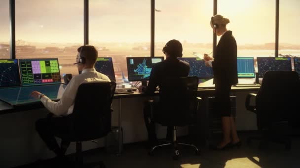 El equipo de control de tráfico aéreo trabaja en la torre del aeropuerto al atardecer — Vídeo de stock