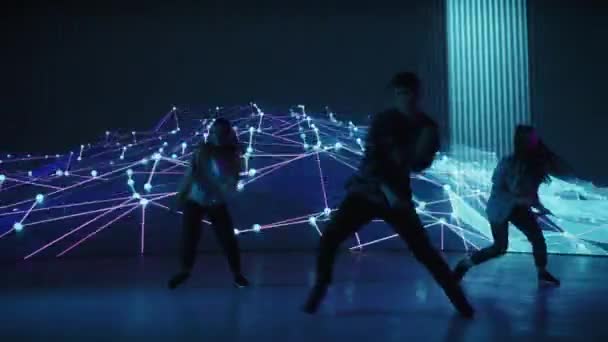 Tři tanečníci vystupující před animovanou digitální obrazovkou — Stock video