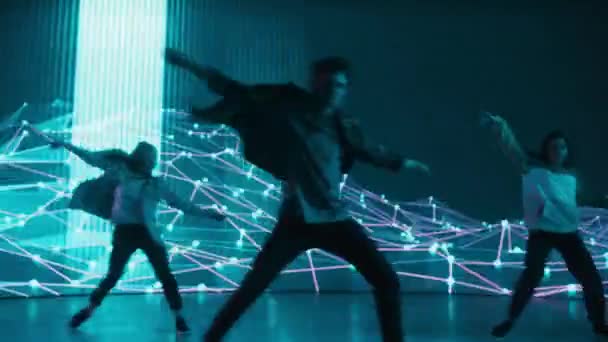 Три танцора выступают перед анимационным цифровым экраном — стоковое видео