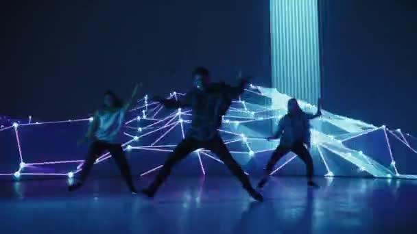 Trzech tancerzy występujących przed animowanym ekranem cyfrowym — Wideo stockowe