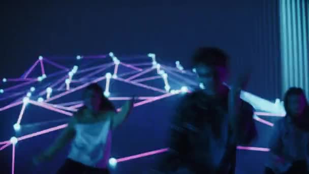 Nahaufnahme von drei Tänzern, die vor einem animierten digitalen Bildschirm auftreten — Stockvideo