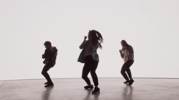 Tři tanečníci vystupující před barevnou digitální obrazovkou — Stock video