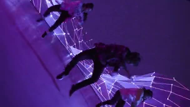 Три танцора выступают перед анимационным цифровым экраном — стоковое видео