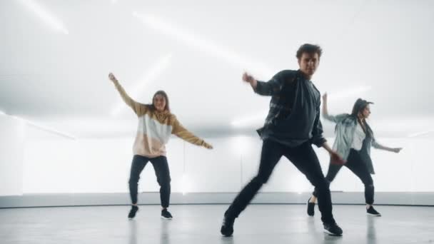 Τρεις χορευτές που εκτελούν μπροστά από την ψηφιακή οθόνη γκαράζ — Αρχείο Βίντεο