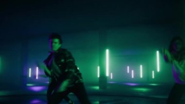 Dijital Neon Garaj Ekranının Önünde Üç Dansçı Gösteriyor