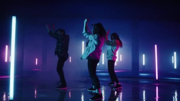 デジタルネオガレージスクリーン前で上演される3人のダンサー — ストック動画