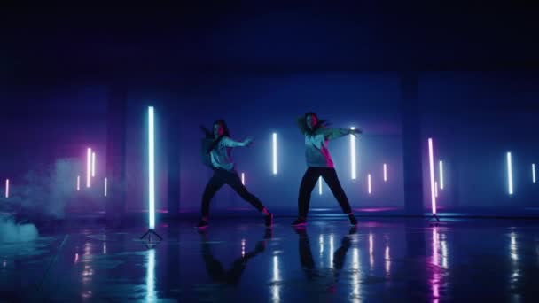 Dos bailarinas que actúan frente a la pantalla del garaje de neón digital — Vídeos de Stock