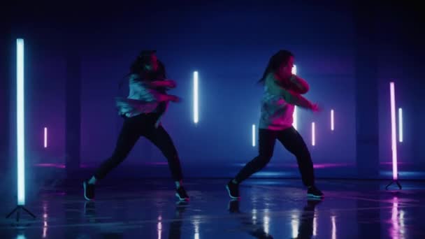 Två kvinnliga dansare framför Digital Neon Garage Screen — Stockvideo