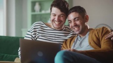 Evde dizüstü bilgisayar kullanan eşcinsel çift.