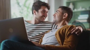 Evde dizüstü bilgisayar kullanan eşcinsel çift.