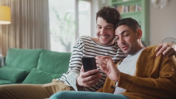 Гей пара використовуючи смартфон вдома — стокове відео