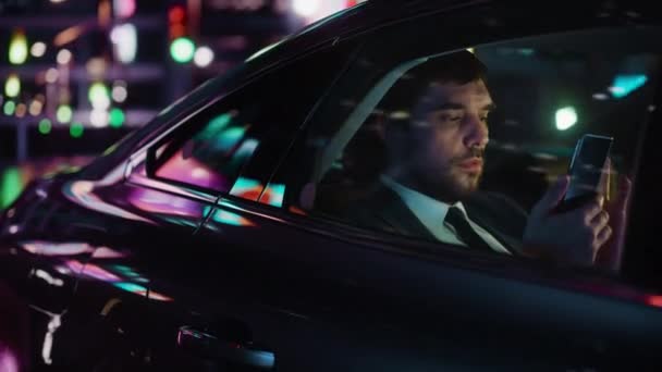 Üzletember autóban a városban éjszaka — Stock videók