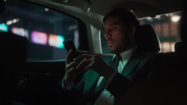 Empresario en coche en la ciudad por la noche — Vídeos de Stock