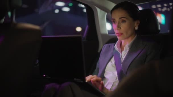 Mujer de negocios en coche en la ciudad por la noche — Vídeos de Stock