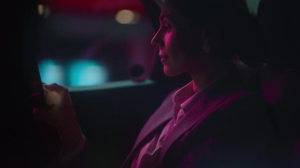 Zakenvrouw in auto in de stad 's nachts — Stockvideo