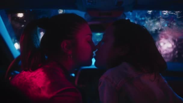 ЛГБТ-жінки цілуються в машині вночі — стокове відео