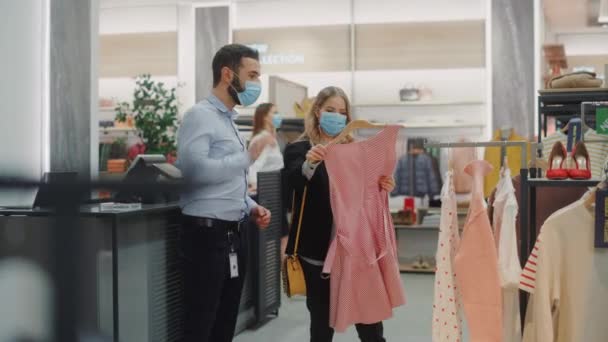 Ruházati bolt a vásárlók visel arc maszkok — Stock videók