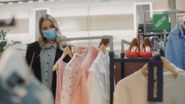 Kledingwinkel met klanten die gezichtsmaskers dragen — Stockvideo