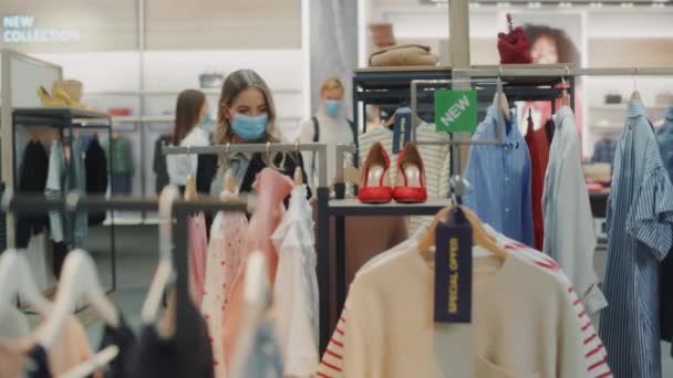Kledingwinkel met klanten die gezichtsmaskers dragen — Stockvideo