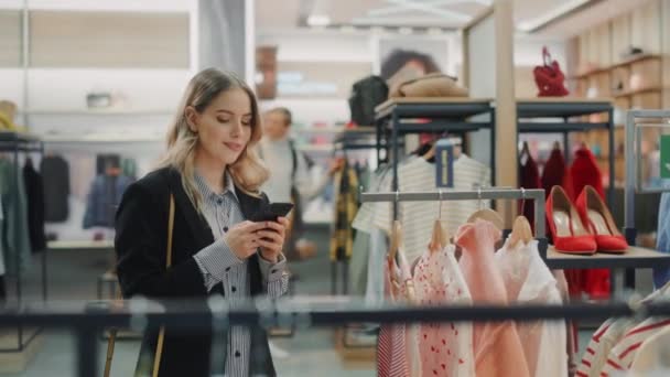 Loja de roupas Cliente usando Smartphone — Vídeo de Stock