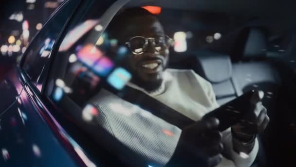 Hombre negro en coche en la ciudad por la noche — Vídeo de stock