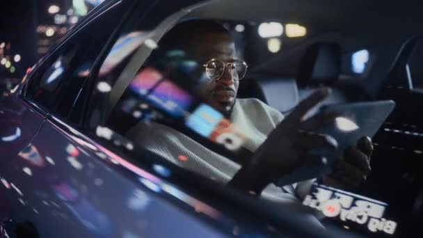 Μαύρος άνδρας στο αυτοκίνητο στην πόλη τη νύχτα — Αρχείο Βίντεο