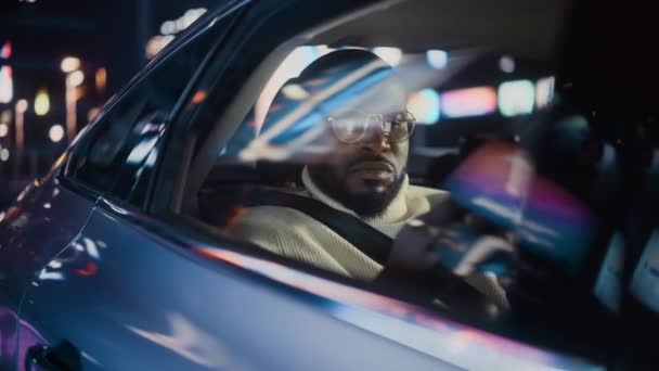 Hombre negro en coche en la ciudad por la noche — Vídeo de stock