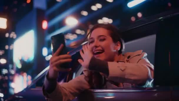Vrouw in auto in de stad 's nachts — Stockvideo