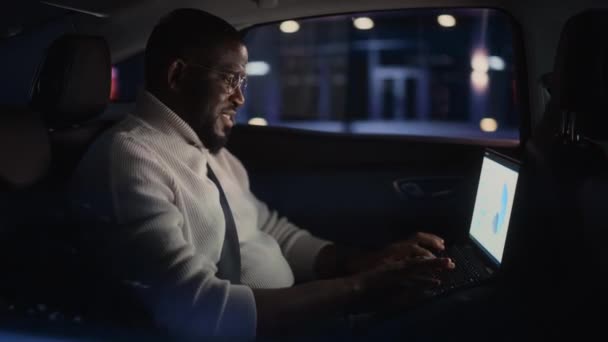 Hombre negro en coche en la ciudad por la noche — Vídeos de Stock