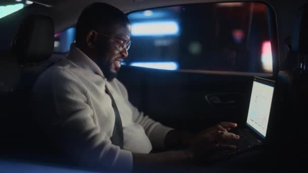 Чернокожий человек в машине в городе ночью — стоковое видео